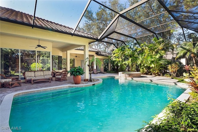 view of pool with outdoor lounge area, ceiling fan, a lanai, an in ground hot tub, and a patio