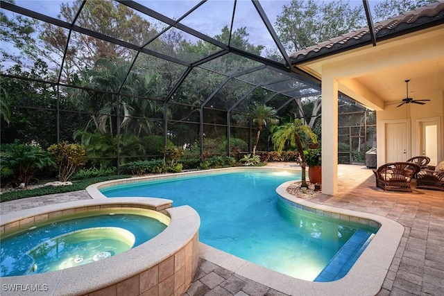 view of swimming pool with ceiling fan, a lanai, an in ground hot tub, and a patio