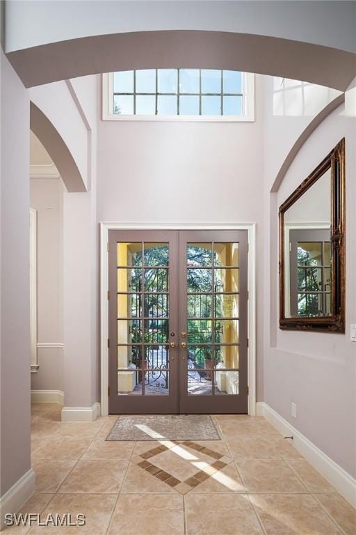 entryway with french doors, light tile patterned floors, and a healthy amount of sunlight