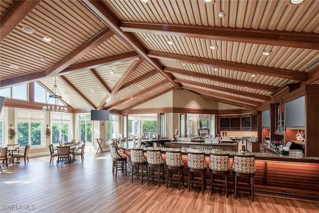 bar featuring hardwood / wood-style floors, high vaulted ceiling, wooden ceiling, and beam ceiling