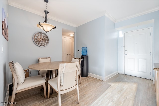 dining space featuring crown molding and light hardwood / wood-style flooring