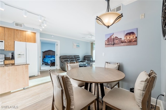 dining room featuring ceiling fan, ornamental molding, rail lighting, and light hardwood / wood-style flooring