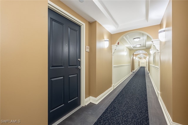 hall featuring dark colored carpet