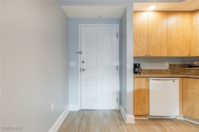 kitchen featuring white dishwasher, light hardwood / wood-style floors, and dark stone counters