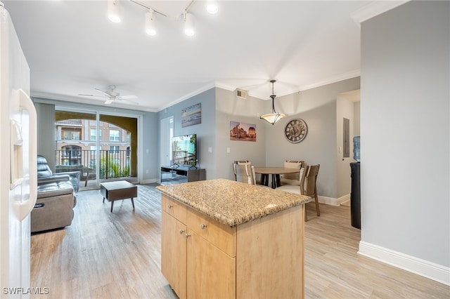 kitchen featuring ceiling fan, light brown cabinets, a center island, light wood-type flooring, and ornamental molding