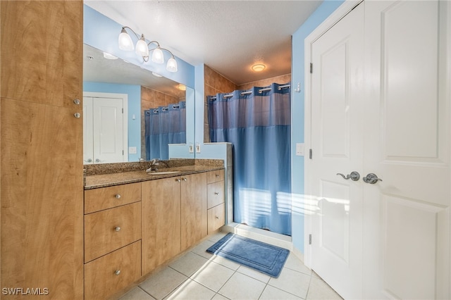 bathroom with tile patterned floors, vanity, a shower with curtain, and a textured ceiling