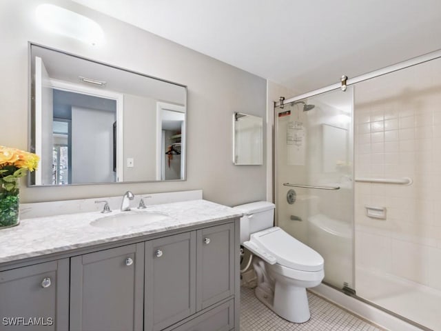 bathroom with tile patterned floors, vanity, toilet, and walk in shower