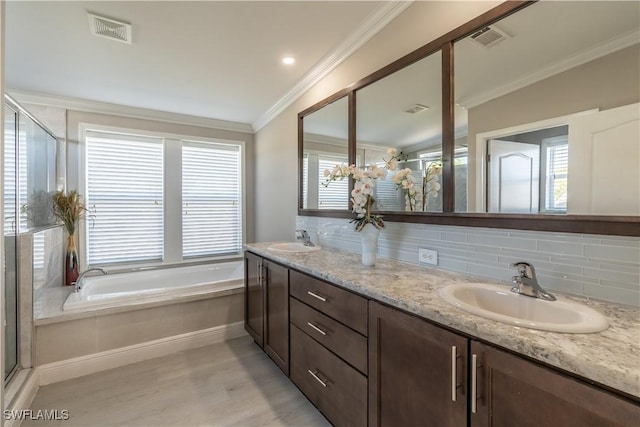 bathroom with tasteful backsplash, ornamental molding, vanity, shower with separate bathtub, and hardwood / wood-style floors