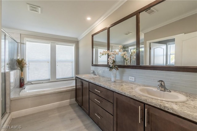 4008 24th Ave NE, Naples, FL 34120 - bathroom featuring wood finished floors, double vanity, a garden tub, backsplash, and a shower stall