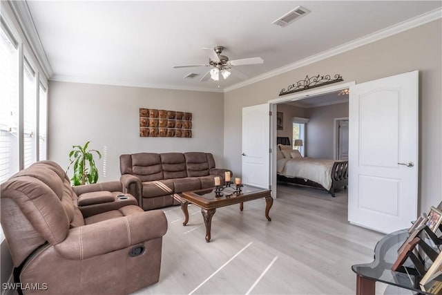 living room featuring ceiling fan, light wood-type flooring, and ornamental molding