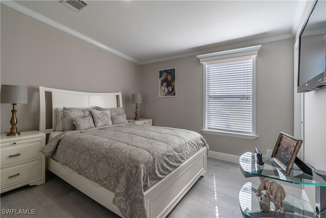 bedroom with light wood-type flooring and ornamental molding