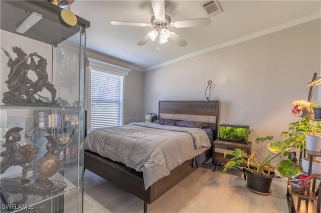 bedroom featuring hardwood / wood-style flooring, ceiling fan, and ornamental molding