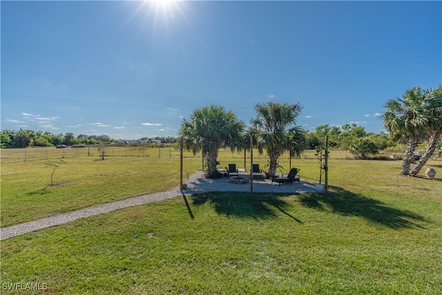 view of home's community featuring a yard, a rural view, and an outdoor fire pit