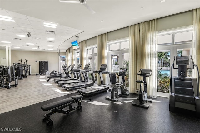 workout area featuring ceiling fan and a drop ceiling