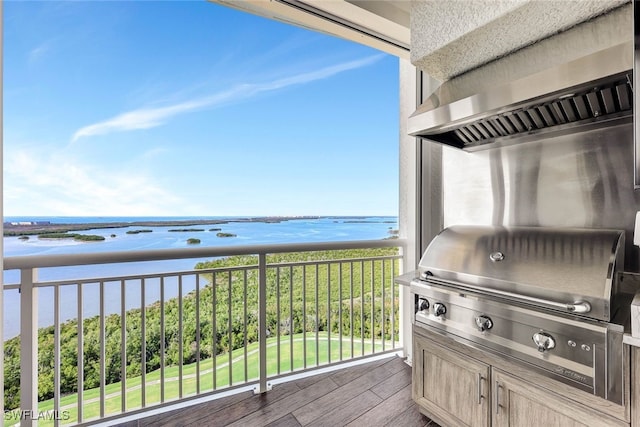 balcony with area for grilling and a water view