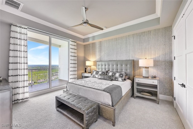 carpeted bedroom with access to outside, a raised ceiling, and ceiling fan