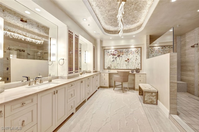 bathroom with vanity, a raised ceiling, and a tile shower