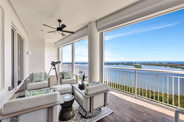 sunroom / solarium featuring ceiling fan and a water view