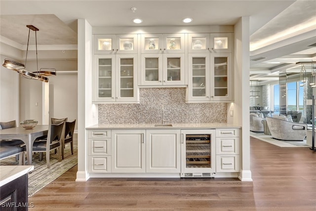 bar featuring wine cooler, white cabinets, decorative light fixtures, and hardwood / wood-style flooring