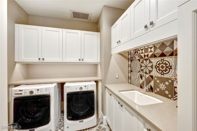 laundry room featuring cabinets, sink, and washer and dryer