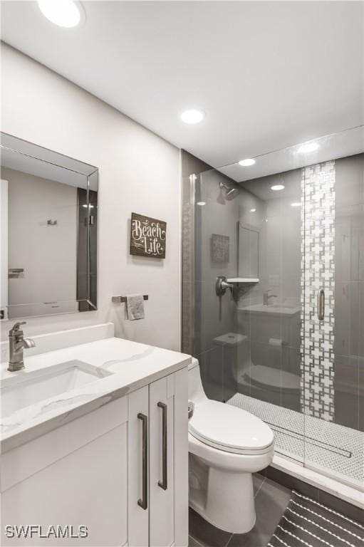 bathroom with vanity, tile patterned flooring, a shower with shower door, and toilet