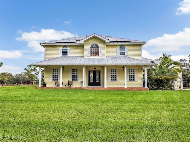 farmhouse inspired home with solar panels, french doors, a porch, and a front lawn