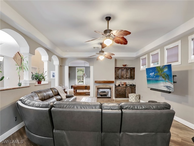 living room featuring hardwood / wood-style flooring, ceiling fan, pool table, and decorative columns