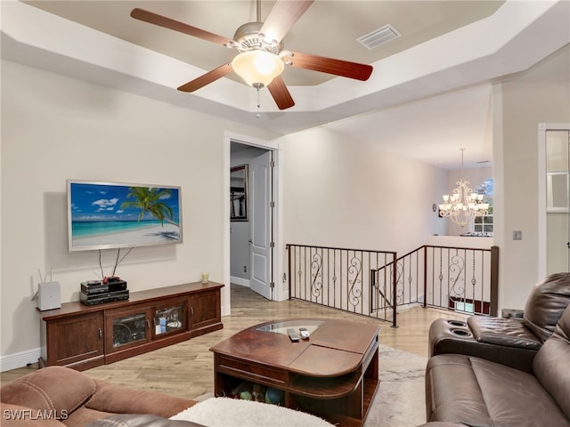 living room with wood-type flooring and ceiling fan with notable chandelier