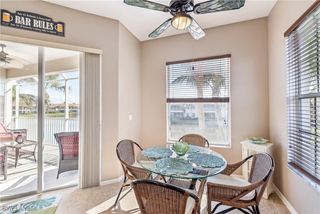 dining area with a healthy amount of sunlight, baseboards, a ceiling fan, and light tile patterned flooring