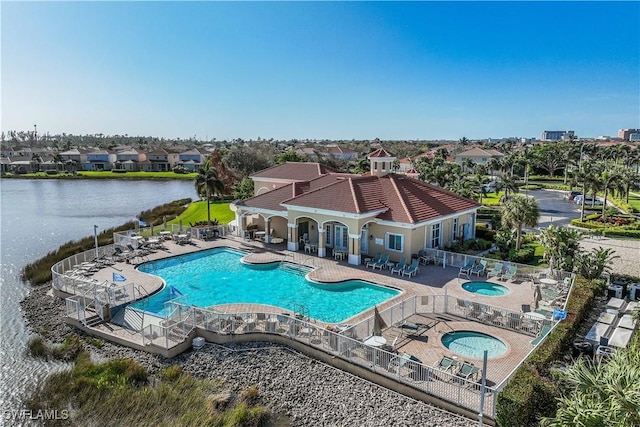 pool featuring a patio, a community hot tub, a water view, fence, and a residential view