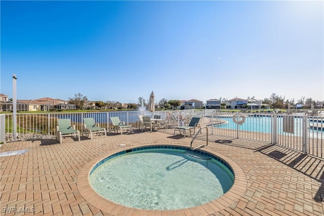 view of swimming pool featuring a water view and a patio