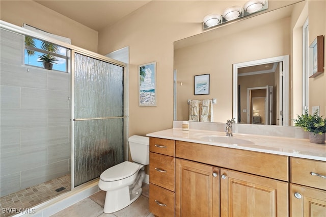 bathroom with tile patterned floors, vanity, a shower with shower door, and toilet