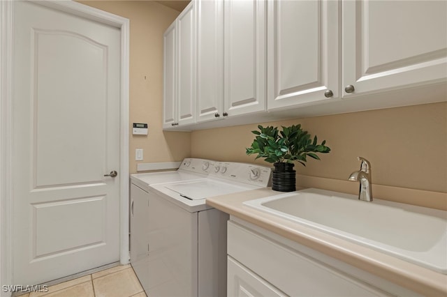 laundry area featuring cabinets, independent washer and dryer, sink, and light tile patterned floors