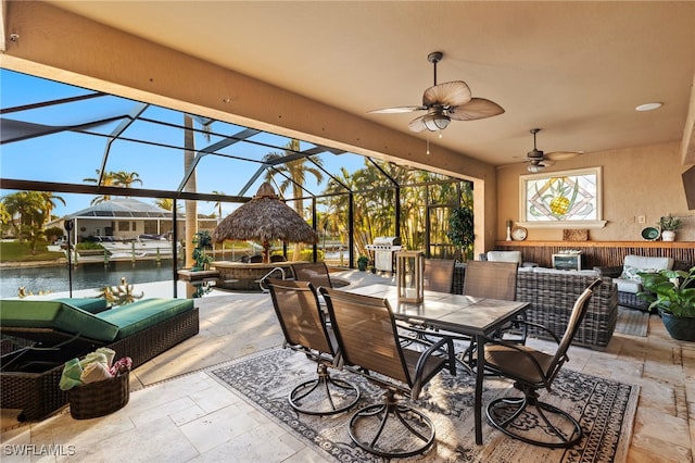 view of patio / terrace with an outdoor hangout area, a water view, ceiling fan, and a lanai