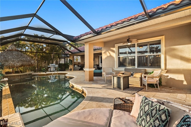 view of pool with outdoor lounge area, a patio, glass enclosure, and ceiling fan