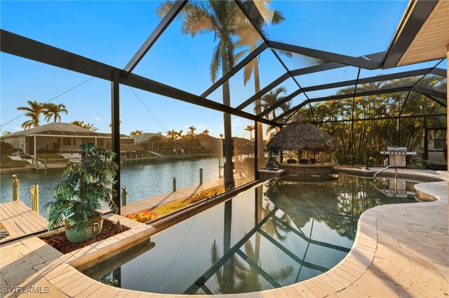 view of pool with a gazebo, a water view, glass enclosure, and a patio area