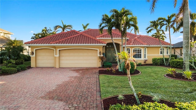 mediterranean / spanish-style home with a front yard and a garage