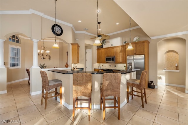 kitchen with ornate columns, kitchen peninsula, decorative light fixtures, a breakfast bar, and appliances with stainless steel finishes