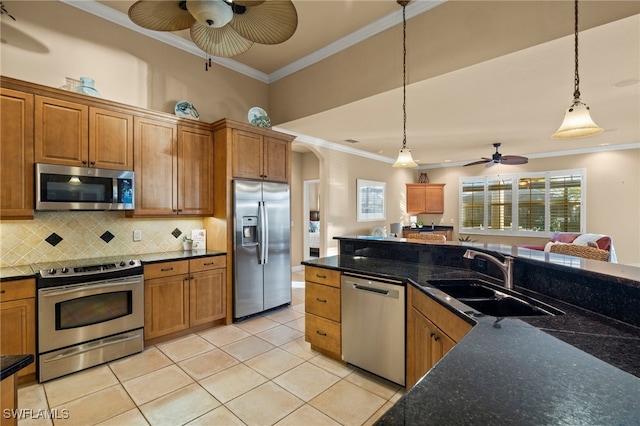 kitchen with appliances with stainless steel finishes, decorative light fixtures, light tile patterned floors, and sink