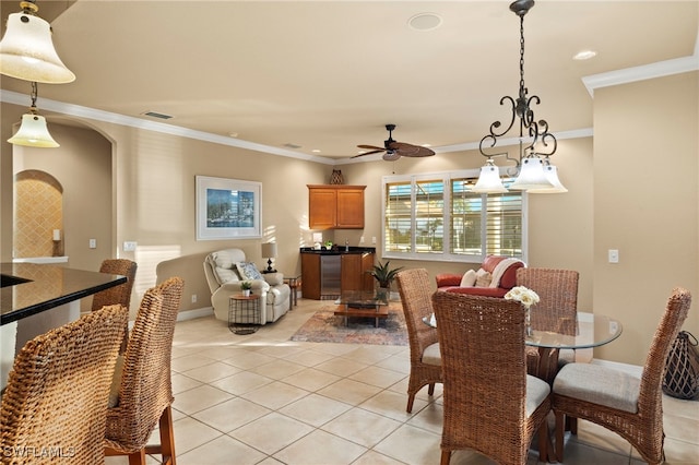 dining area with ceiling fan, light tile patterned floors, and crown molding