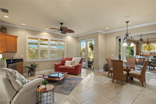 tiled living room featuring ceiling fan and crown molding