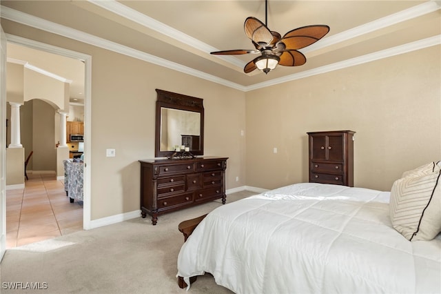 carpeted bedroom with ceiling fan, ornate columns, and ornamental molding