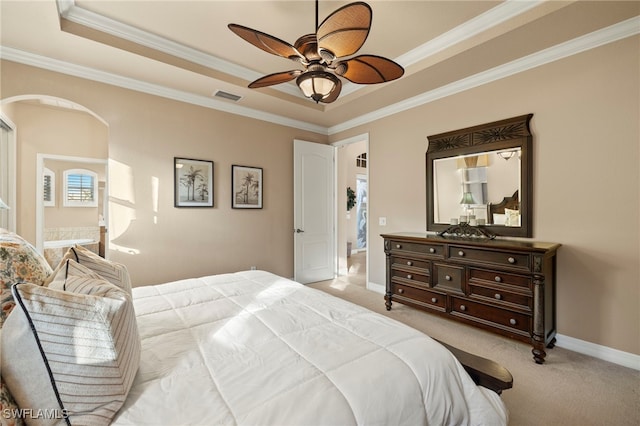 bedroom with ceiling fan, light colored carpet, crown molding, and a tray ceiling