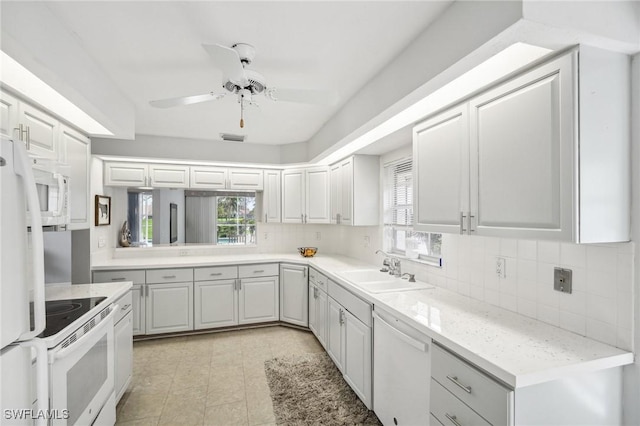 kitchen with white appliances, white cabinetry, and a healthy amount of sunlight