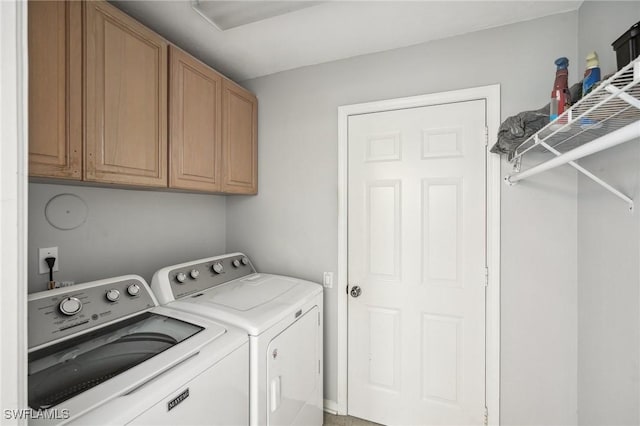 washroom featuring washer and dryer and cabinets