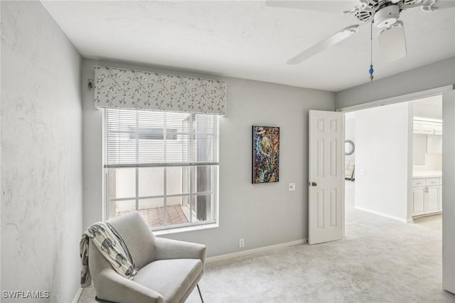 living area featuring ceiling fan and light colored carpet