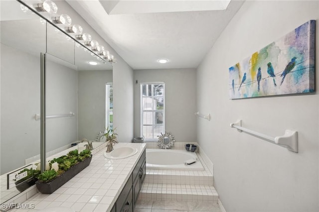 bathroom with tile patterned floors, tiled bath, and vanity