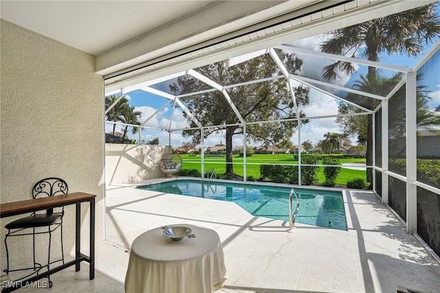 view of swimming pool with a patio area and a lanai