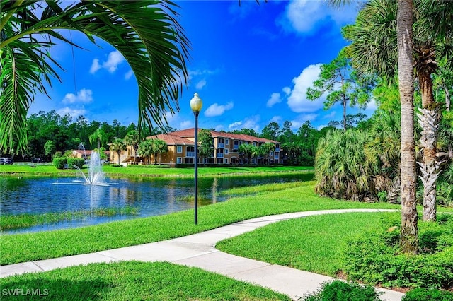 view of home's community with a lawn and a water view