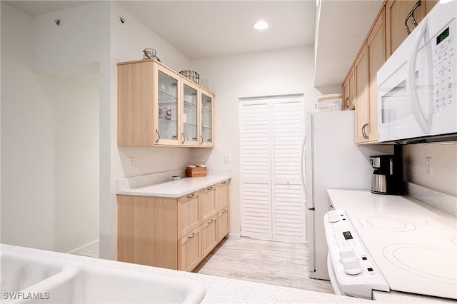 kitchen featuring light hardwood / wood-style floors, stove, sink, and light brown cabinetry